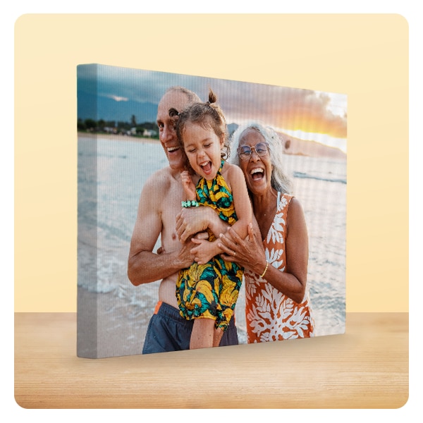 A 16 by 20 photo canvas showing grandparents with their grandchild at the beach.