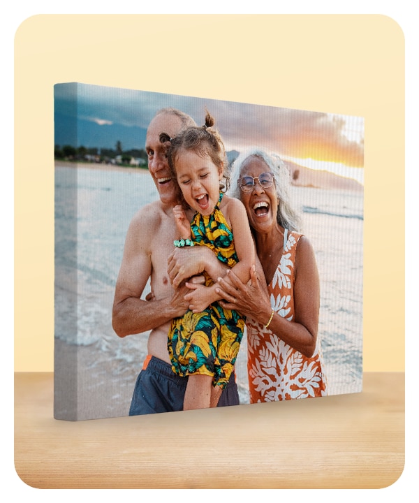 A 16 by 20 photo canvas showing grandparents with their grandchild at the beach.