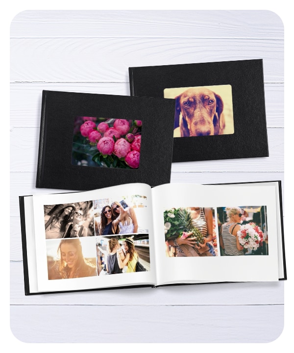 Three photo books. The two books on top are closed and show peonies on one cover and a dog on the other cover. The photo book beneath them is opened to a spread showing pictures of friends.